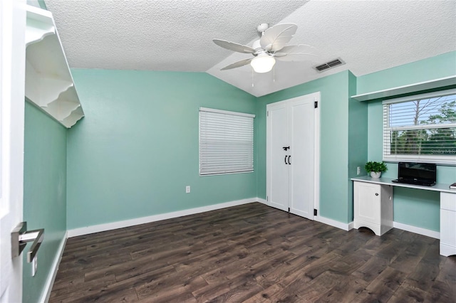 unfurnished bedroom featuring ceiling fan, vaulted ceiling, a textured ceiling, and dark hardwood / wood-style flooring