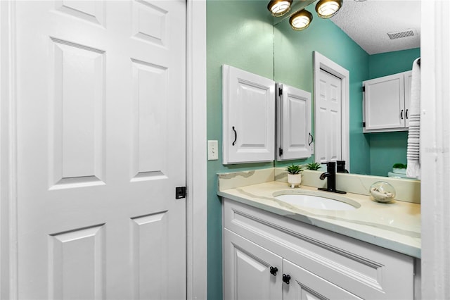 bathroom with vanity and a textured ceiling