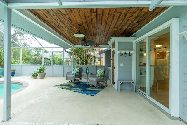 exterior space with a fenced in pool, ceiling fan, and glass enclosure