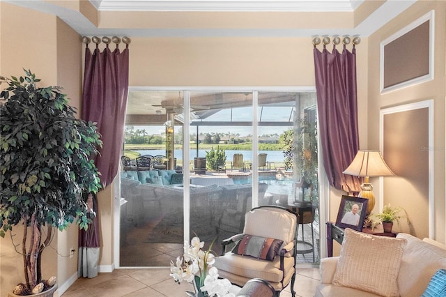 sitting room featuring a water view, light tile patterned floors, and crown molding