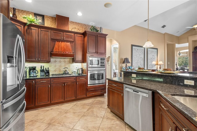 kitchen with decorative backsplash, appliances with stainless steel finishes, premium range hood, ceiling fan, and decorative light fixtures