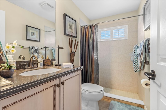 bathroom with walk in shower, tile patterned floors, vanity, and toilet