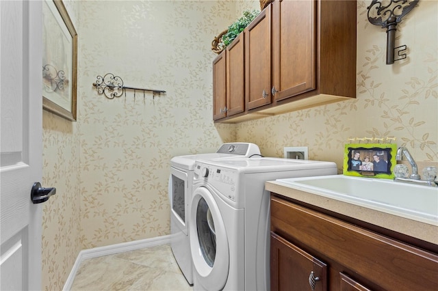 laundry room with cabinets, sink, and washing machine and dryer