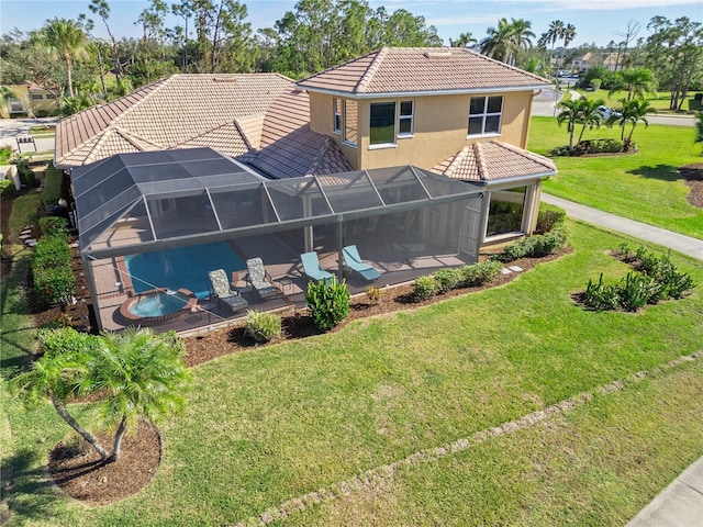 rear view of property featuring a yard, a patio area, and a lanai