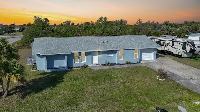 single story home featuring a lawn and a garage