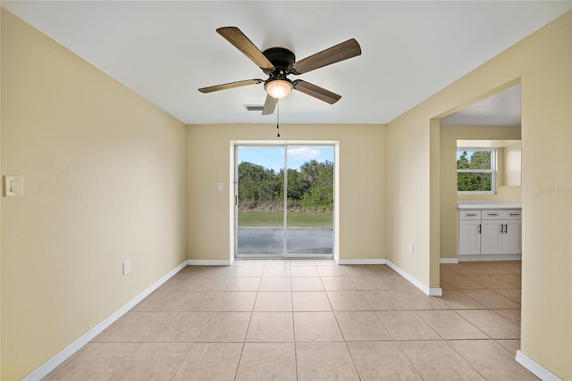 empty room featuring ceiling fan and light tile patterned floors