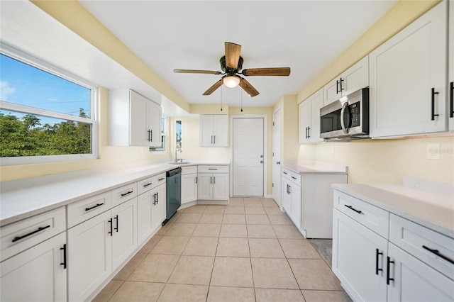 kitchen featuring appliances with stainless steel finishes, ceiling fan, sink, light tile patterned floors, and white cabinets