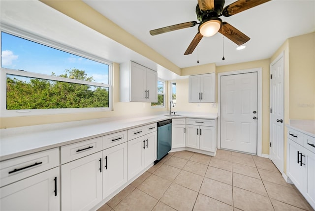 kitchen featuring light tile patterned floors, white cabinetry, stainless steel dishwasher, and sink