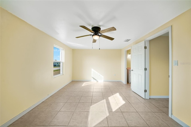 tiled spare room with ceiling fan