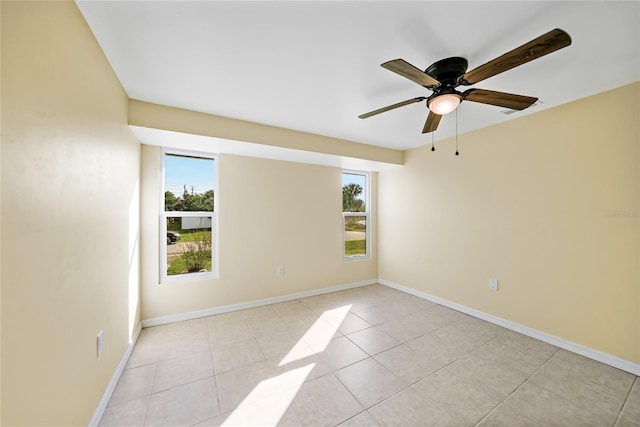 tiled spare room with ceiling fan