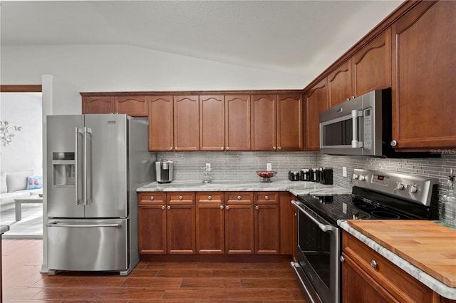 kitchen featuring tasteful backsplash, appliances with stainless steel finishes, lofted ceiling, and dark hardwood / wood-style flooring