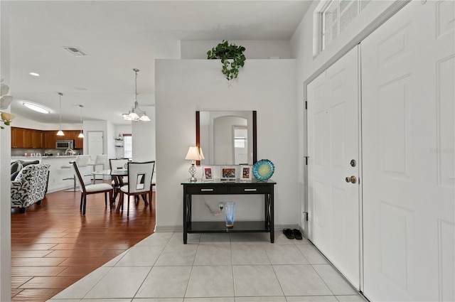 entryway featuring an inviting chandelier and light hardwood / wood-style flooring