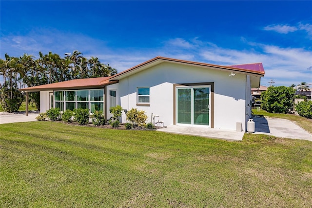 rear view of property with a yard and a patio