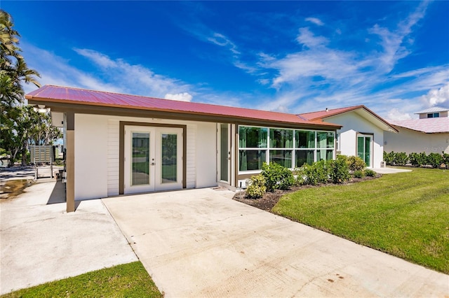 view of front of home featuring a front lawn and french doors