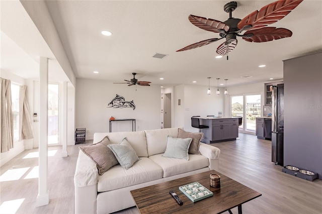 living room featuring ceiling fan and light hardwood / wood-style flooring