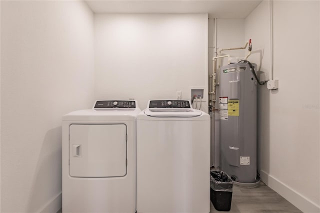 washroom with hardwood / wood-style floors, washer and dryer, and water heater