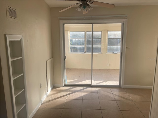 tiled empty room featuring ceiling fan