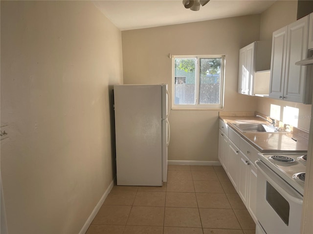 kitchen with light tile patterned floors, white appliances, white cabinetry, and sink