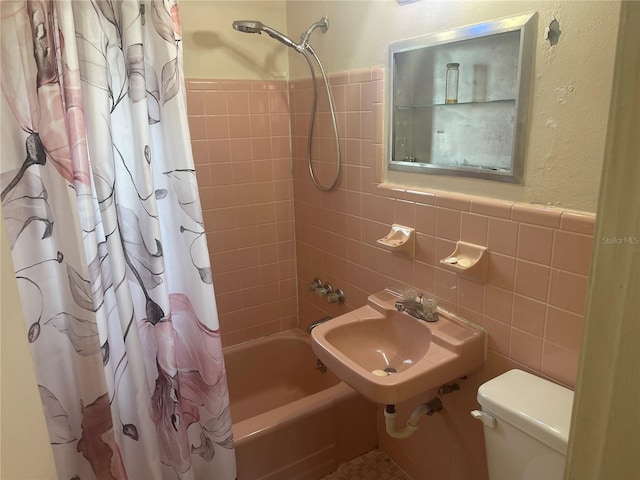 full bathroom featuring shower / bath combination with curtain, toilet, sink, and tile walls