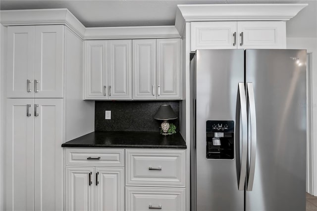 kitchen with stainless steel fridge with ice dispenser, decorative backsplash, and white cabinets