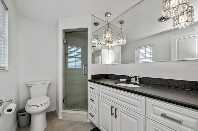 bathroom featuring toilet, tile patterned floors, a shower with shower door, and vanity