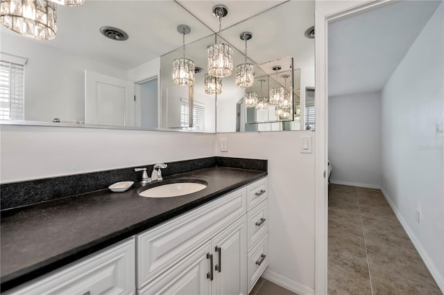 bathroom with vanity, an inviting chandelier, and tile patterned flooring