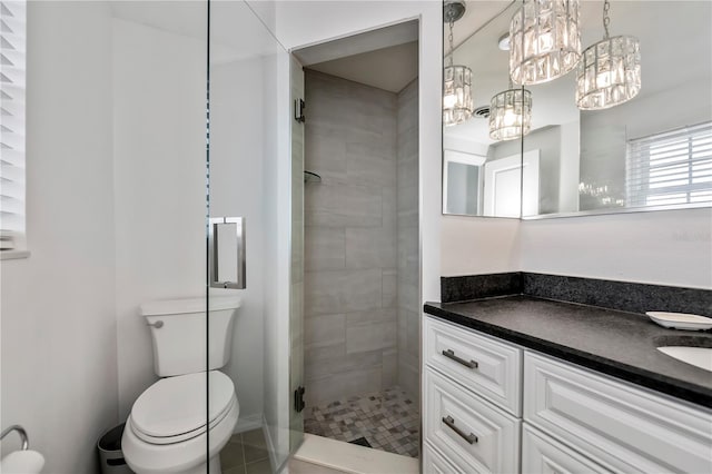 bathroom featuring toilet, a shower with shower door, a notable chandelier, tile patterned flooring, and vanity