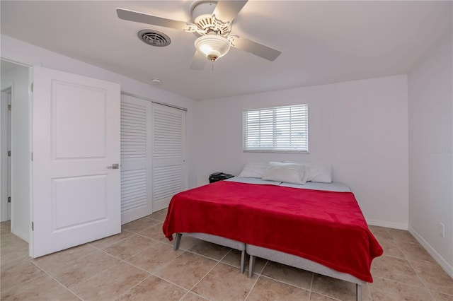 tiled bedroom featuring ceiling fan and a closet