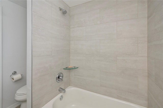 bathroom featuring toilet and tiled shower / bath