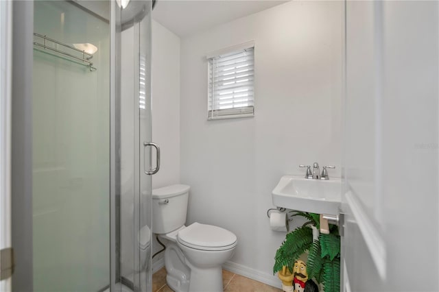 bathroom with toilet, tile patterned floors, walk in shower, and sink