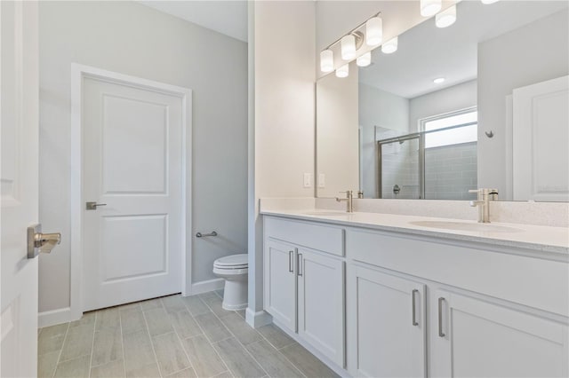 bathroom featuring toilet, an enclosed shower, and vanity