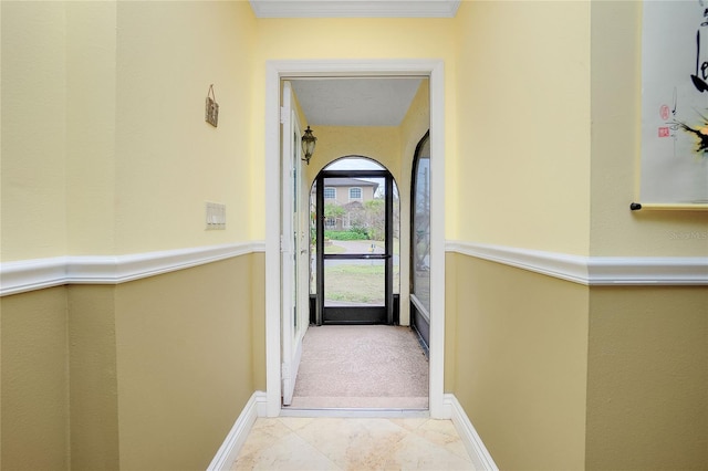 hallway featuring light tile patterned floors and ornamental molding