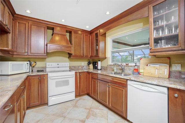 kitchen with custom exhaust hood, sink, white appliances, light stone countertops, and light tile patterned floors