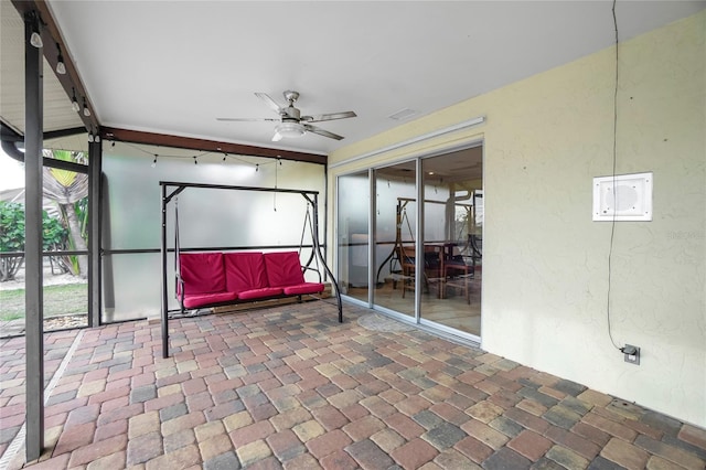 unfurnished sunroom featuring ceiling fan