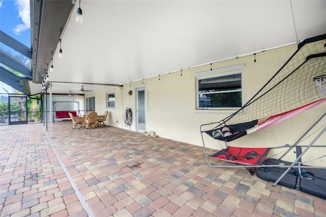 view of patio featuring glass enclosure and ceiling fan