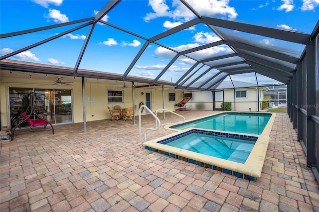 view of pool with a lanai, ceiling fan, an in ground hot tub, and a patio