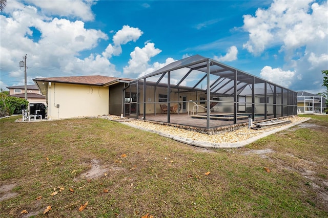 back of house with a lanai, a patio area, and a lawn