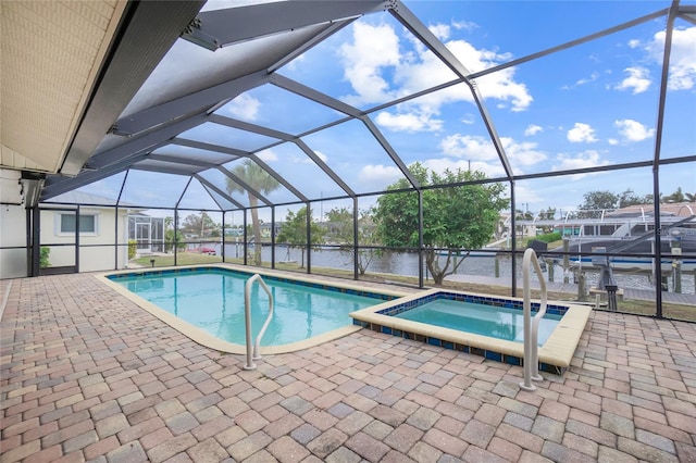 view of pool featuring a lanai, a water view, a patio area, and an in ground hot tub