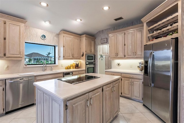 kitchen with light brown cabinetry, sink, a kitchen island, and stainless steel appliances