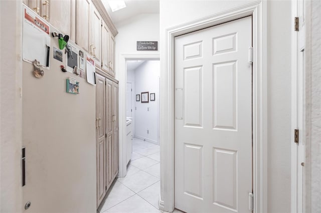 hallway with light tile patterned flooring and lofted ceiling