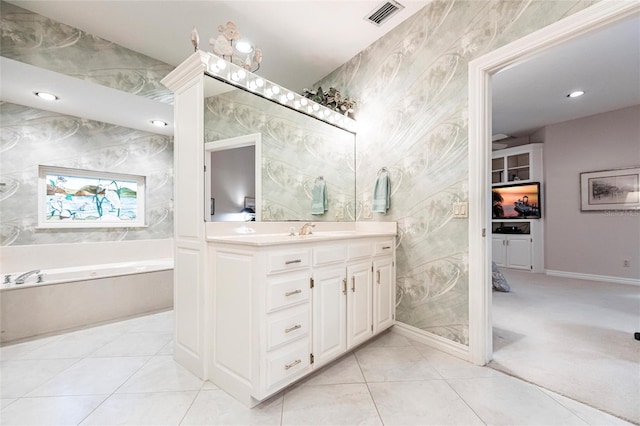 bathroom with tile patterned floors, vanity, and a bath