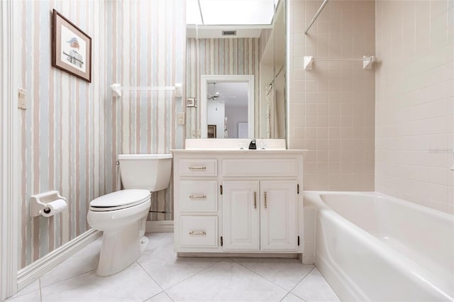 full bathroom featuring vanity, tile patterned flooring, ceiling fan, tiled shower / bath combo, and toilet