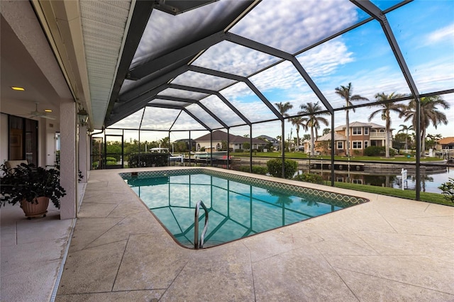 view of swimming pool with a patio, a water view, ceiling fan, and a lanai