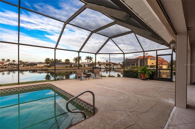 view of pool with a lanai, a patio area, and a water view