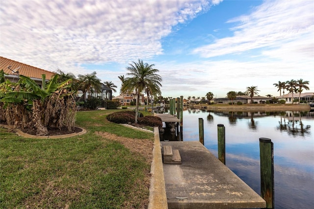 view of dock with a yard and a water view