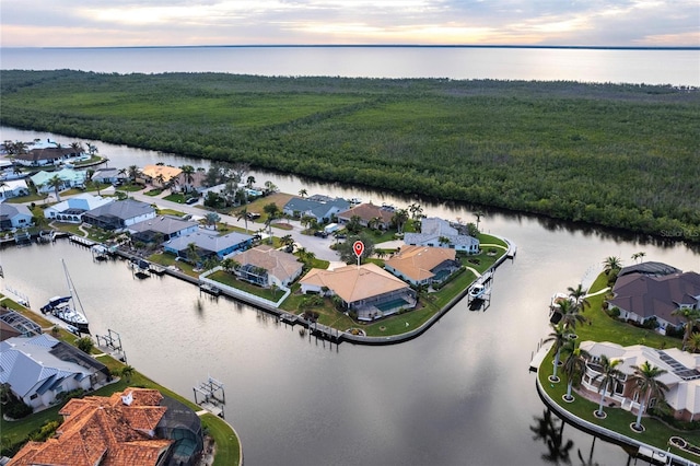 aerial view at dusk featuring a water view