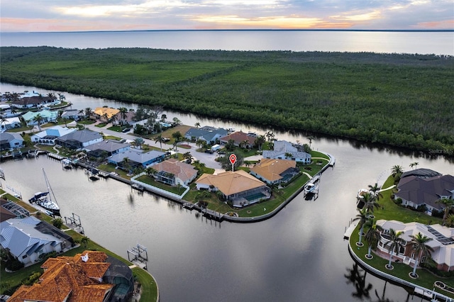 aerial view at dusk featuring a water view