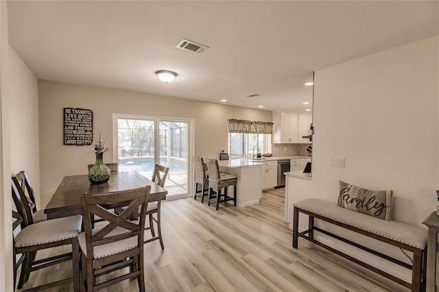 dining area with sink and light hardwood / wood-style flooring