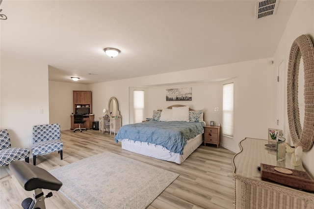 bedroom featuring multiple windows and light hardwood / wood-style flooring