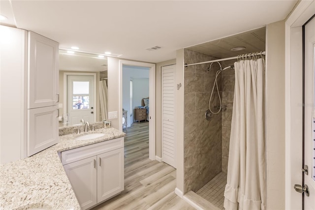 bathroom featuring curtained shower, vanity, and hardwood / wood-style flooring